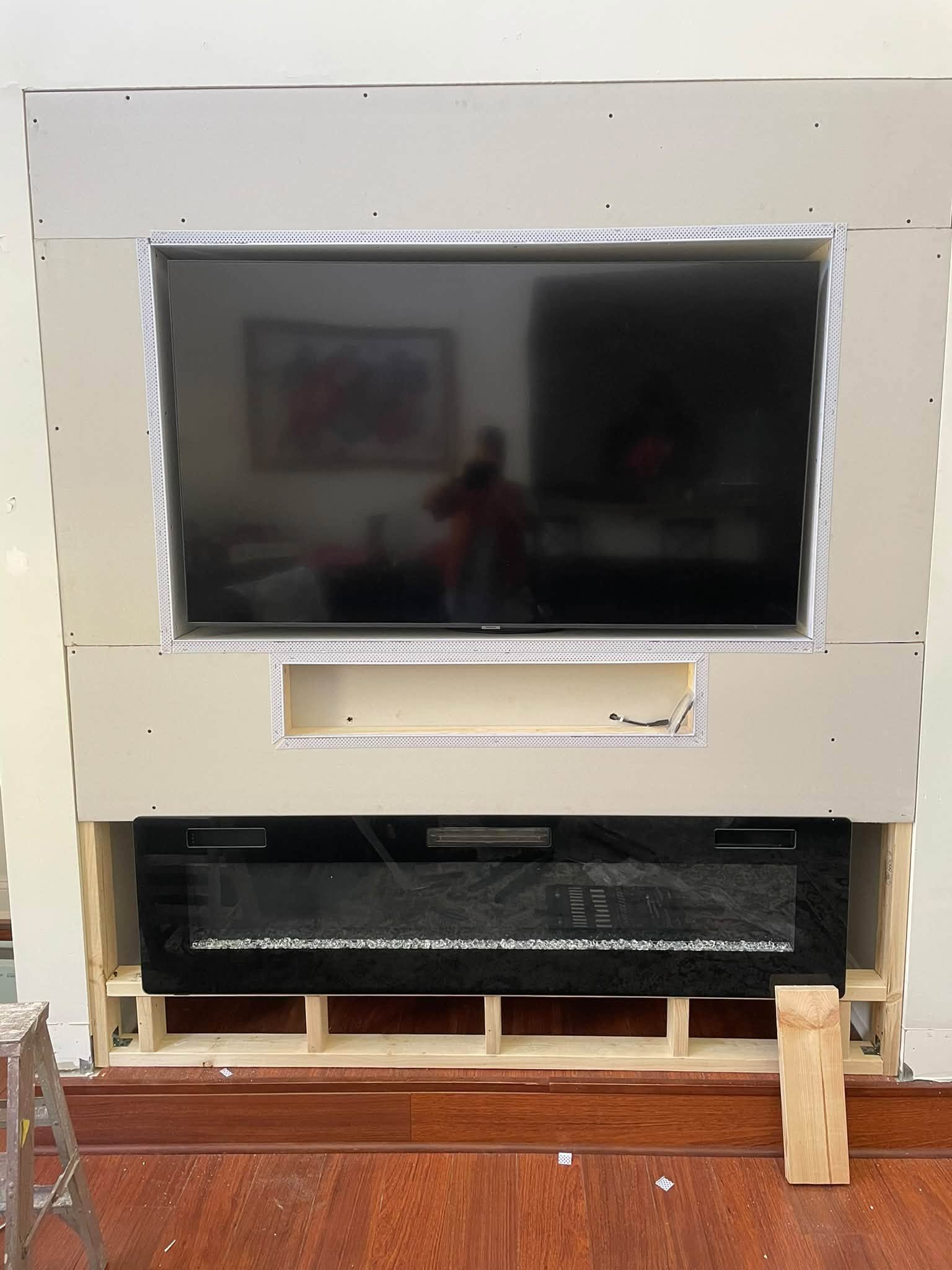 Shelving and fireplace surround being built as part of a custom media-wall project