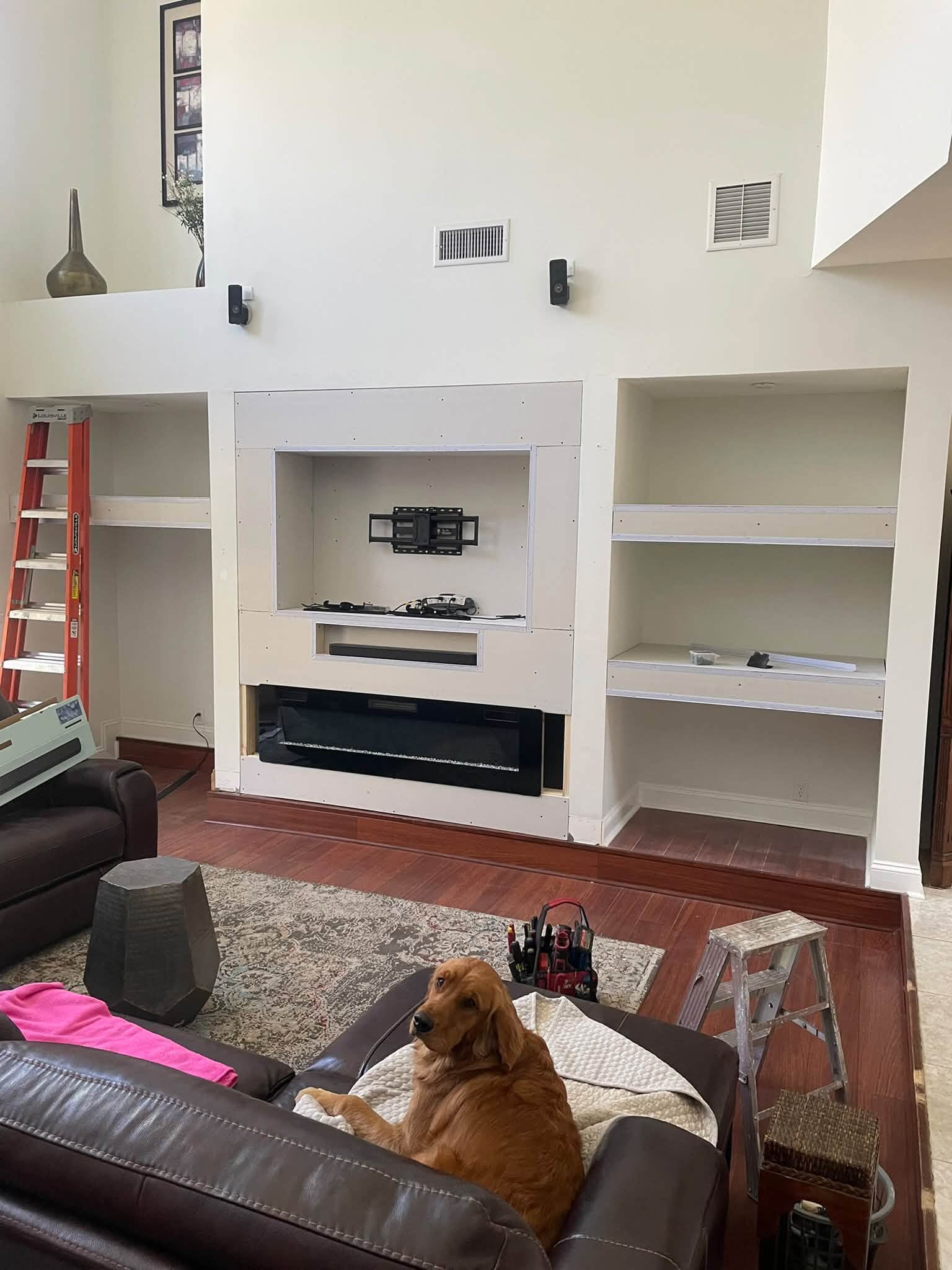 Custom media wall with shelves and a fireplace during construction, photographed by All-Round Handyman